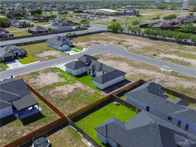 an aerial view of a house with a garden and lake view