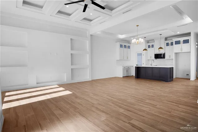 a view of empty room with wooden floor and window