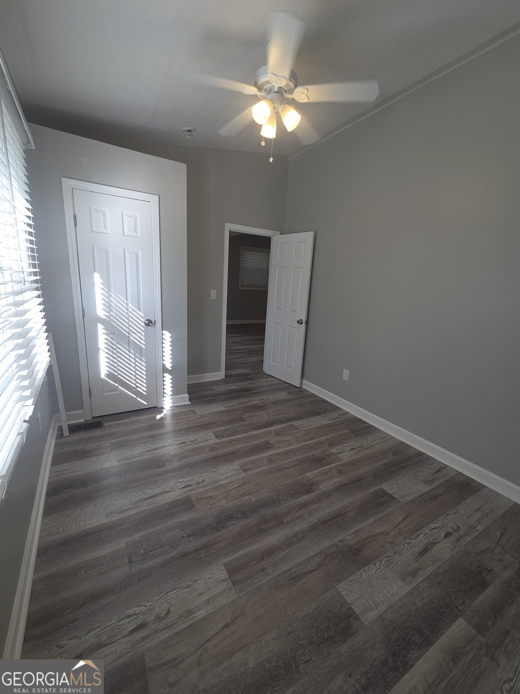 1126 Briarcliff Place Northeast, Unit 2 Atlanta, GA 30306 - Photo 11 of 12 an empty room with wooden floor chandelier fan and windows