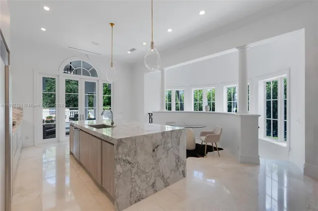 a large kitchen with kitchen island a large counter top space a sink stainless steel appliances and cabinets