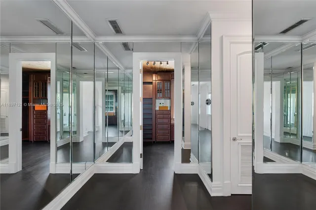 a view of a hallway with wooden floors and a bathroom