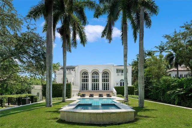 a view of a house with a swimming pool and palm trees