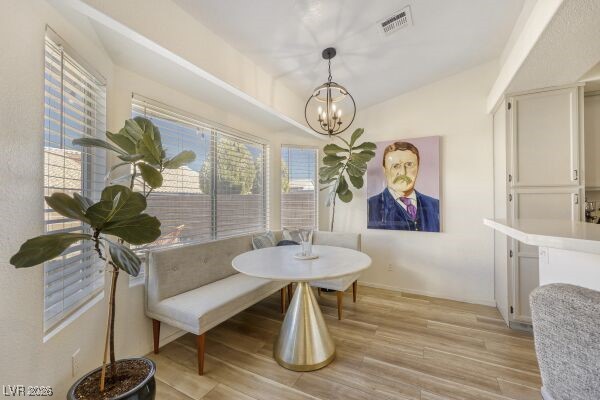 1536 Pony Ranch Circle Henderson, NV 89014 - Photo 12 of 24 Dining space featuring light wood-style flooring, a chandelier, and lofted ceiling