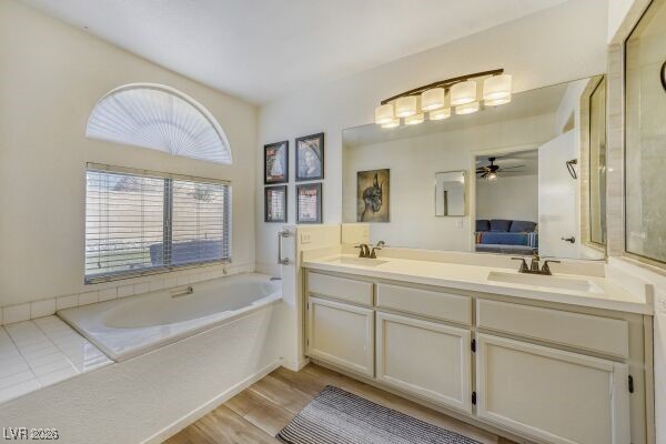 1536 Pony Ranch Circle Henderson, NV 89014 - Photo 16 of 24 Ensuite bathroom featuring double vanity, a bath, light wood-style flooring, and ceiling fan
