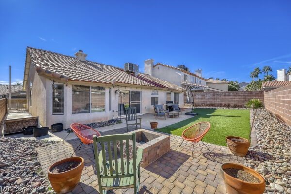 1536 Pony Ranch Circle Henderson, NV 89014 - Photo 22 of 24 Rear view of property with a patio area, a chimney, a fenced backyard, an outdoor fire pit, and a tile roof