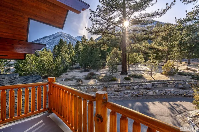 a front view of a house with a yard balcony and trees