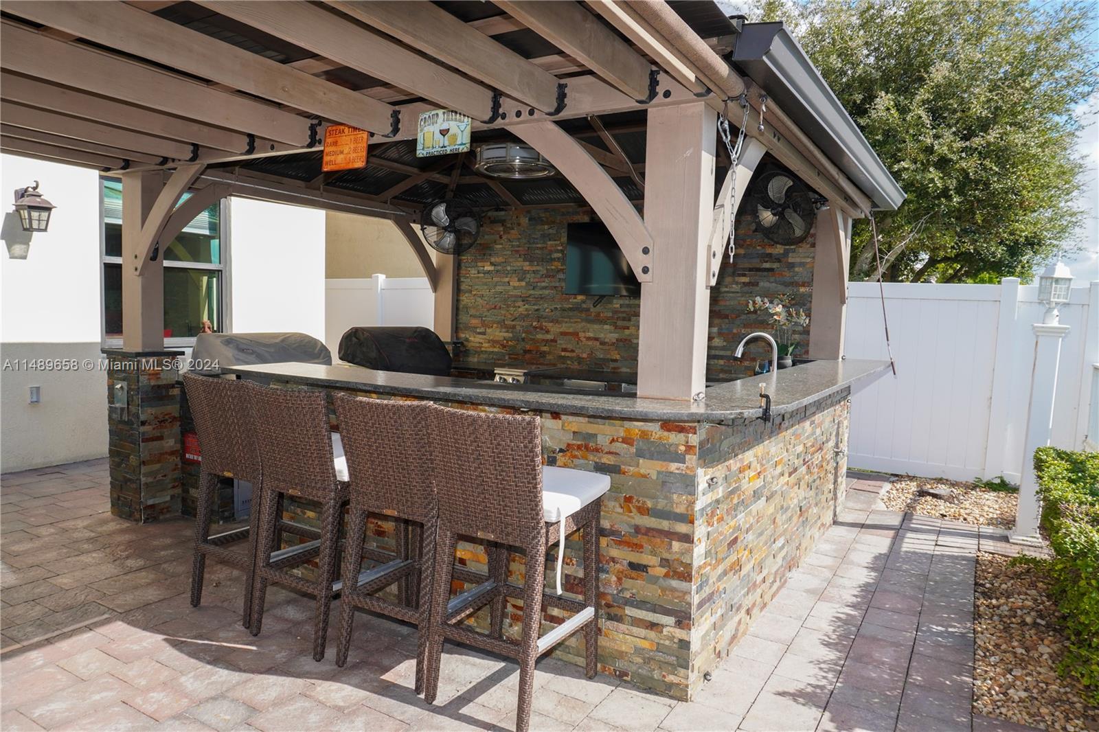 3522 West 88th Street Hialeah, FL 33018 - Photo 42 of 52 a view of a patio with table and chairs with wooden floor and fence