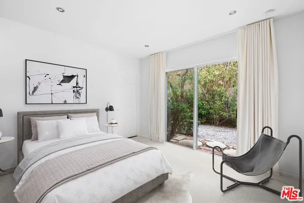 a bedroom with furniture and a large window