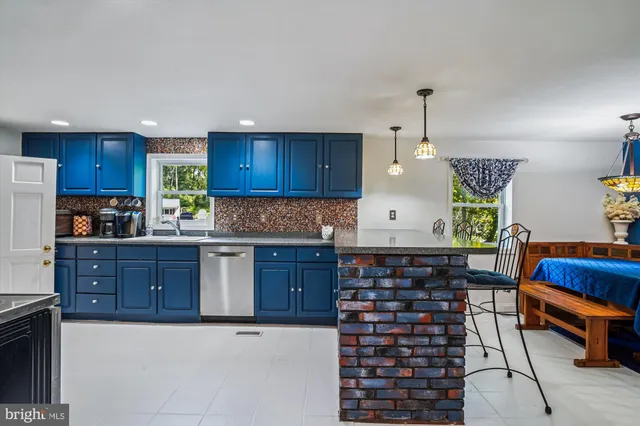 a kitchen with granite countertop a stove a sink a window and cabinets