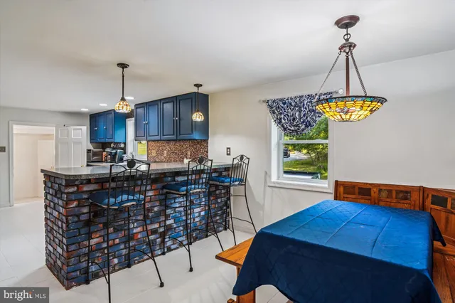 a kitchen with stainless steel appliances a table chairs and chandelier