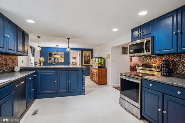 a kitchen with stainless steel appliances granite countertop wooden cabinets a stove top oven a sink and dishwasher