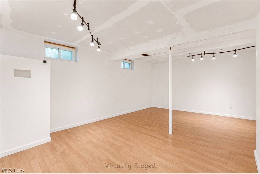 16107 Moseley Road Madison, OH 44057 - Photo 24 of 40 Basement Spacious room featuring light wood-finish flooring, white walls, and track lighting