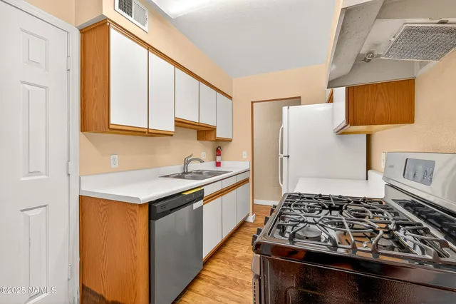 a kitchen with a stove a sink and a refrigerator
