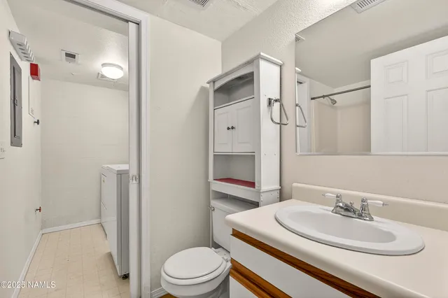 a bathroom with a sink a toilet and shower
