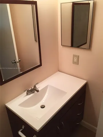 a bathroom with a sink vanity and a mirror