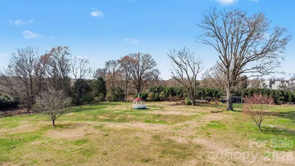 a swimming pool with lots of tress in the background