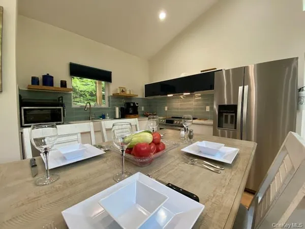 a kitchen with stainless steel appliances kitchen island granite countertop a refrigerator and a sink