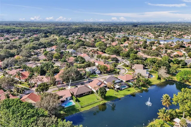 an aerial view of residential houses with outdoor space and trees