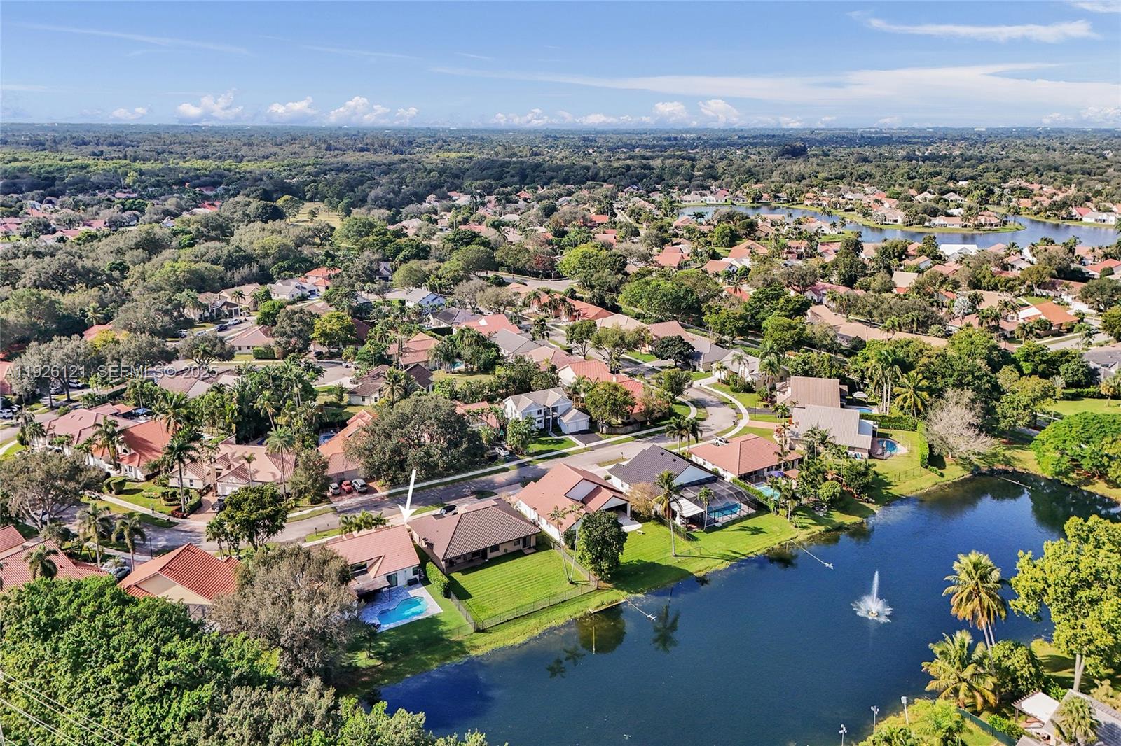 an aerial view of residential houses with outdoor space and trees