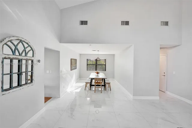a living room with furniture a dining table and a chandelier
