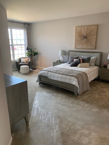 489 Ridge Road Bolingbrook, IL 60440 - Photo 16 of 34 a spacious bedroom with a bed a couch and windows