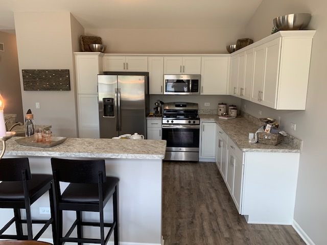 489 Ridge Road Bolingbrook, IL 60440 - Photo 6 of 34 a kitchen with stainless steel appliances a sink a stove a refrigerator cabinets and a dining table