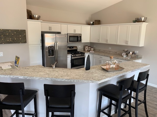489 Ridge Road Bolingbrook, IL 60440 - Photo 7 of 34 a kitchen with stainless steel appliances granite countertop a table chairs microwave and refrigerator