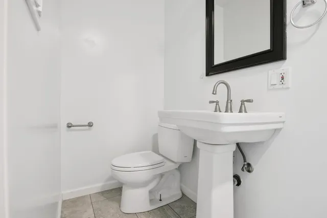 a bathroom with a sink toilet and mirror