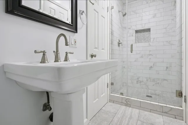 a bathroom with a sink a mirror and shower