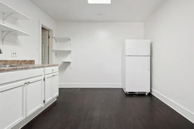 an empty room with wooden floor and cabinets
