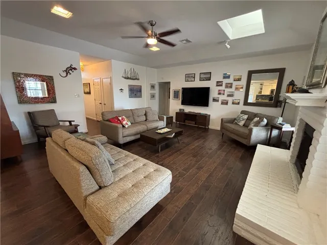 a living room with furniture flat screen tv and wooden floor