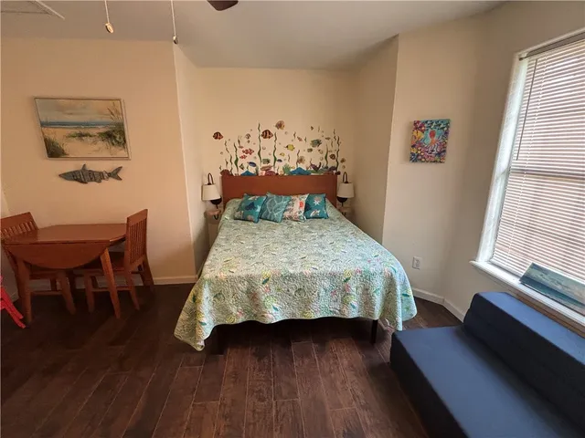 a bedroom with a bed and wooden floor