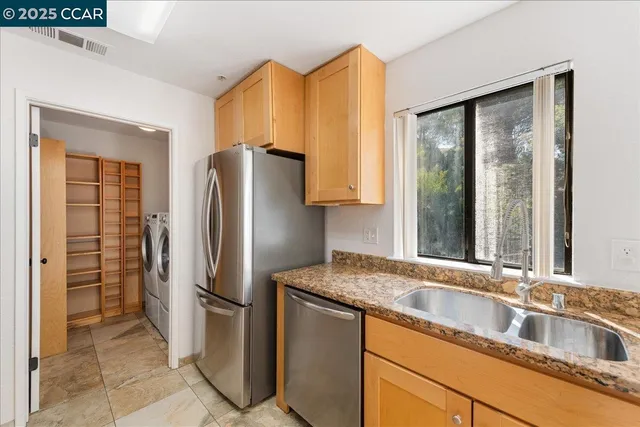 a kitchen with stainless steel appliances granite countertop a refrigerator and a sink