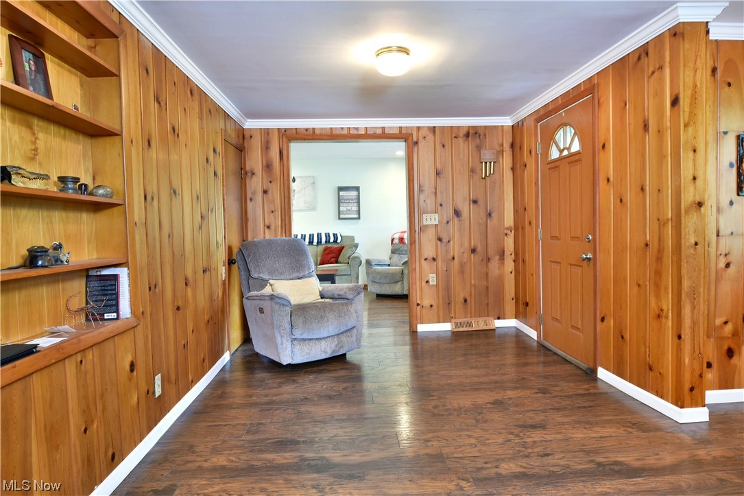 1711 Salt Springs Road Mineral Ridge, OH 44440 - Photo 6 of 35 Sitting room featuring wood walls, dark hardwood floors, and crown molding