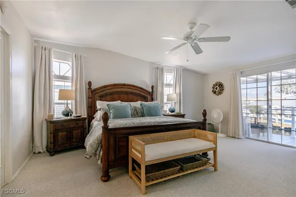 a view of a lake with lawn chairs under an umbrella