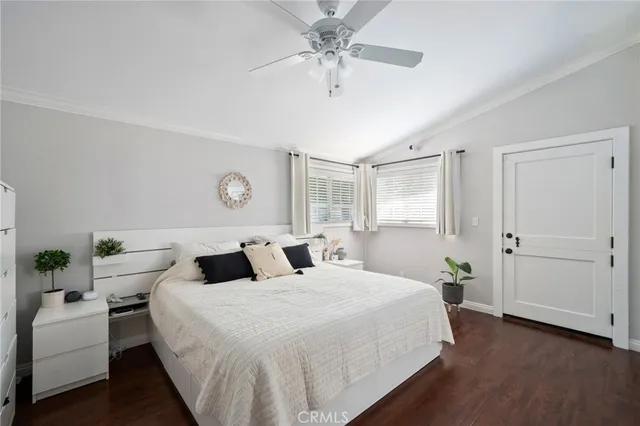 a bedroom with a large bed and a chandelier fan