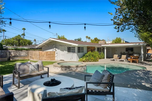 a view of a house with backyard and sitting area