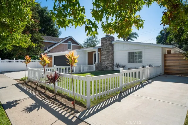 a view of a house with a small yard and wooden fence
