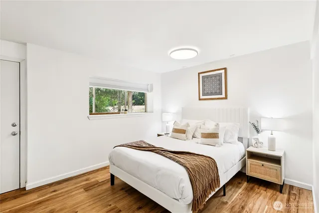 a bedroom with a bed and wooden floor