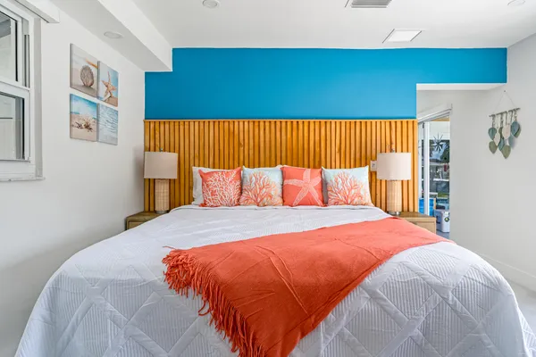 a bed room with a bed a couch and a large window