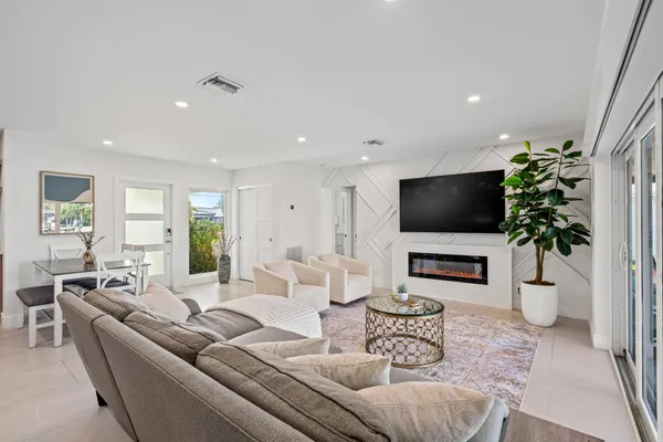 a living room with furniture a flat screen tv and a potted plant