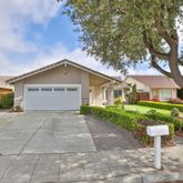 a view of a house with a yard and large trees