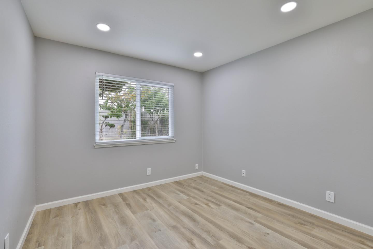 365 San Andreas Drive Milpitas, CA 95035 - Photo 18 of 26 en empty room with wooden floor and windows