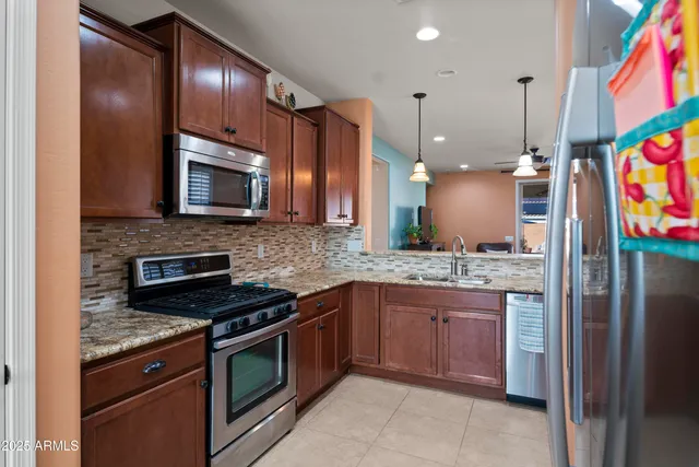 a kitchen with stainless steel appliances granite countertop a stove a sink and a microwave