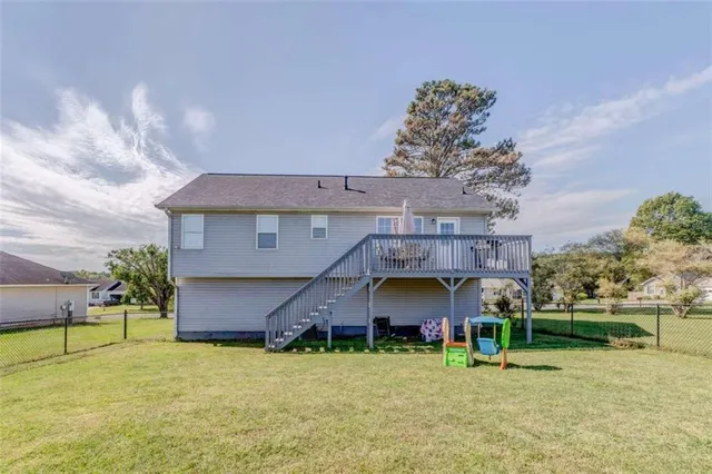 a view of a swimming pool with a patio and a yard