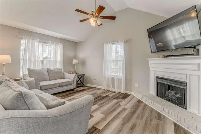 a living room with furniture a flat screen tv and a fireplace