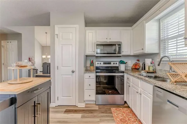 a kitchen with stainless steel appliances a stove sink microwave and cabinets