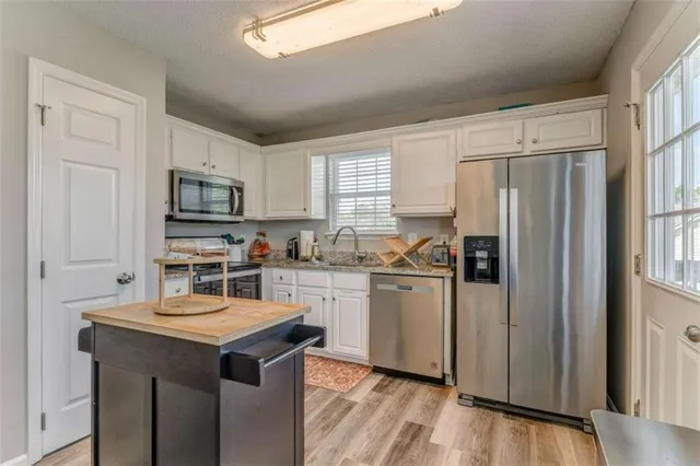 a kitchen with white cabinets and stainless steel appliances