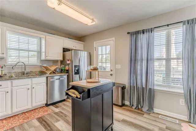 a kitchen with granite countertop a sink stove and refrigerator