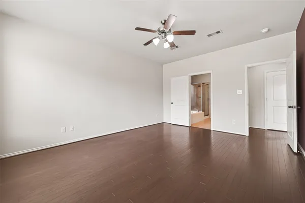 a view of an empty room with wooden floor